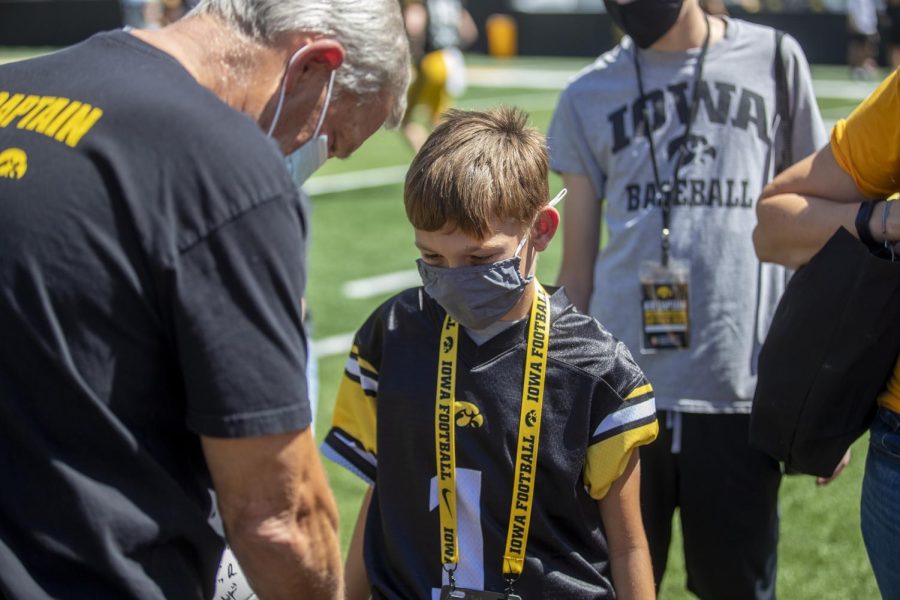 Iowa kid captain Blake Burdof waits for an autograph from head coach Kirk Ferentz during “Kid’s Day at Kinnick” inside Kinnick Stadium on Saturday, Aug. 14. 