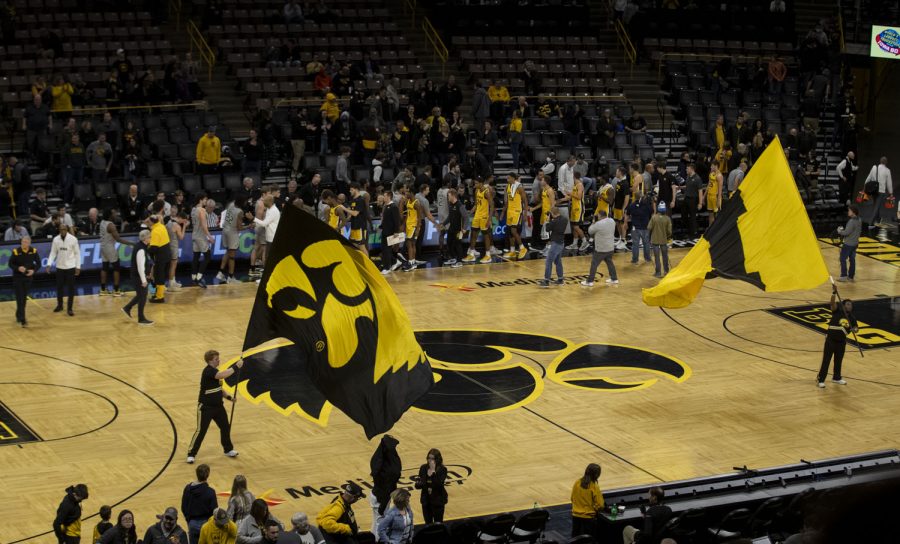 The+Iowa+spirit+squad+waves+flags+at+the+end+of+the+game+while+both+teams+shake+hands+during+a+men%E2%80%99s+basketball+game+between+Iowa+and+Western+Michigan+at+Carver-Hawkeye+Arena+in+Iowa+City+on+Monday+Nov.+22%2C+2021.+The+Hawkeyes+defeated+the+Broncos+109-61.+