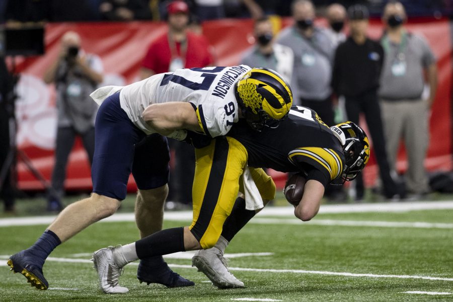 Iowa quarterback Spencer Petras gets sacked by Michigan defensive end Aidan Hutchinson during the Big Ten Championship game between No. 13 Iowa and No. 2 Michigan at Lucas Oil Stadium in Indianapolis, Indiana, on Saturday, Dec. 4, 2021.