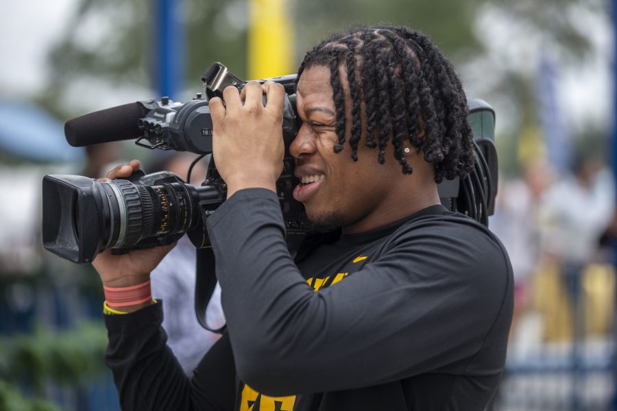 Iowa defensive back Kaevon Merriweather uses a TV reporter’s camera to film teammates during the Vrbo Citrus Bowl Day for Kids at Fun Spot America Theme Park in Orlando, Fla., on Thursday, Dec. 30, 2021. Citrus Bowl Day for Kids is a 2022 Vrbo Citrus Bowl sponsored event that hosts both Iowa and Kentucky. Players from both teams grouped up with children and participated in rides and various activities around the theme park.