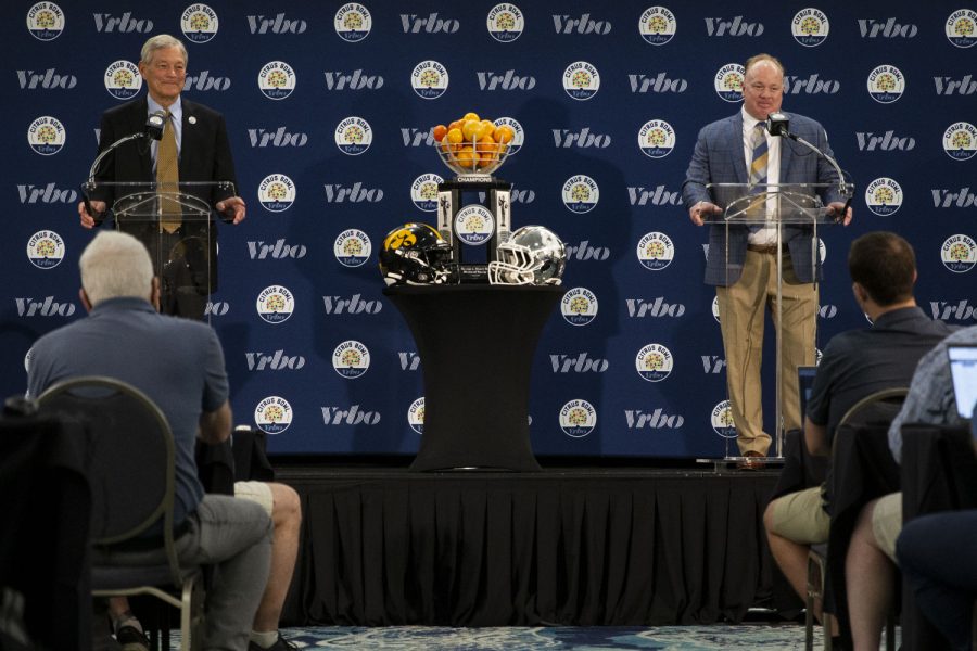 Iowa head coach Kirk Ferentz and Kentucky head coach Mark Stoops stand on a podium during a head coach press conference for the 2022 Vrbo Citrus Bowl at Rosen Plaza Hotel in Orlando, Fla., on Friday, Dec. 31, 2021. Both shared fond memories of Iowa head coach Hayden Fry. Stoops shared that Fry traveled to his father’s funeral. “He flew in just to pay respects to my mother and our family,” Stoops said. “It says an awful lot about him. He had a great impact on myself, my brothers, and so many other players.”