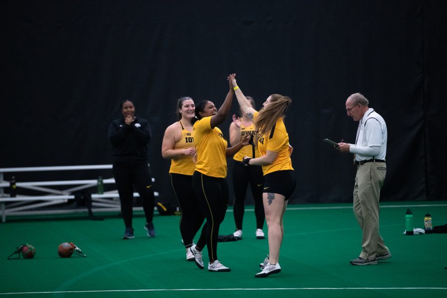University of Iowa weight throwers Nia Britt and Amanda Howe high five each other during the Jimmy Grant Invitational track meet at the Hawkeye Tennis and Recreation Complex in Iowa City on Saturday, Dec. 11, 2021. Members Drake, Northern Illinois, Iowa and Wisconsin were featured at the meet. 