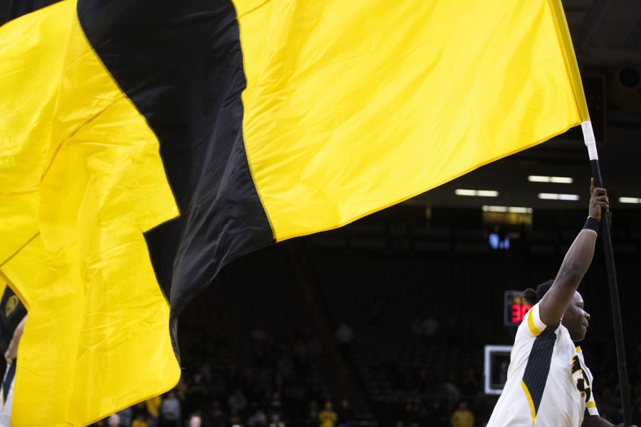 A member of the Iowa spirit squad carries an Iowa flag before a basketball game between Iowa and Southeastern Louisiana at Carver-Hawkeye Arena in Iowa City on Tuesday, Dec. 21, 2021. The Hawkeyes defeated the Lions 93-62. 