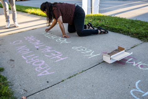 Madelaine Todd writes a pro-choice message on the sidewalk outside the Emma Goldman Clinic on Thursday, Sept. 9, 2021.