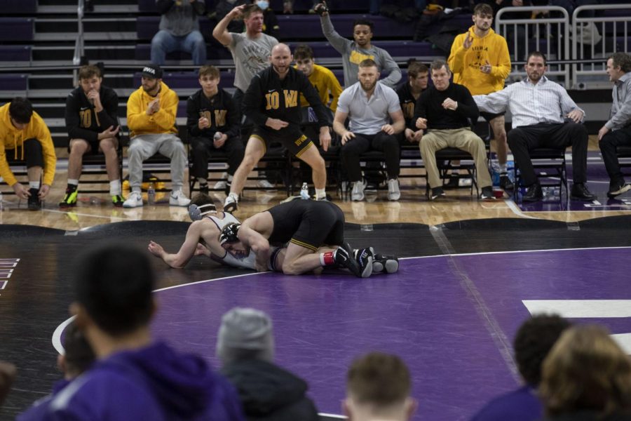 Iowa’s 157-pound No. 12 Kaleb Young wrestles Northwestern’s Trevor Chumbley during a dual at Welsh-Ryan Arena in Evanston, IL. Young defeated Chumbley by decision 6-4.