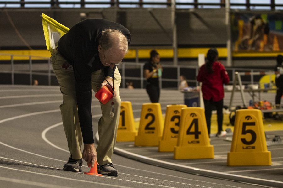 An official picks up cones after a race during the 2022 Hawkeye Invitational track and field meet at the University of Iowa Recreation Building on Saturday, Jan. 15, 2022. The Hawkeye Invitational hosted Arkansas State, Bradley, Hawkeye Community College, Indian Hills Community College, Iowa Central Community College, Loyola-Chicago, Northern Iowa, South Dakota, UW-Milwaukee, and Western Illinois.