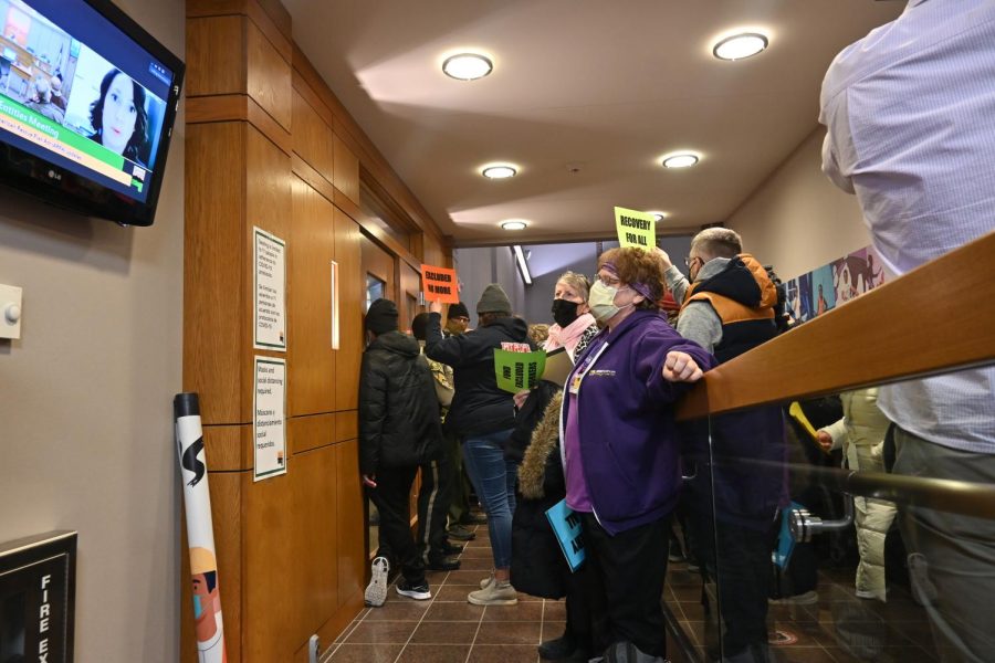 Protesters stand outside the Board of Supervisors meeting at the Johnson County Administration Building on Monday, Jan. 24, 2022. The doors were closed to the public today. The guard at the door told community members that if they wanted to know what was happening, they can live-stream the meeting or watch it on the television outside the room. 