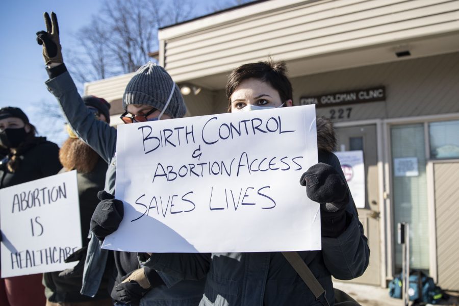 Pro-choice attendees hold up signs during a protest and counter protest between pro-life and pro-choice individuals at Emma Goldman Clinic for reproductive health care in Iowa City on Saturday, Jan. 22, 2022. Around 30 pro-choice individuals attended the protest. 