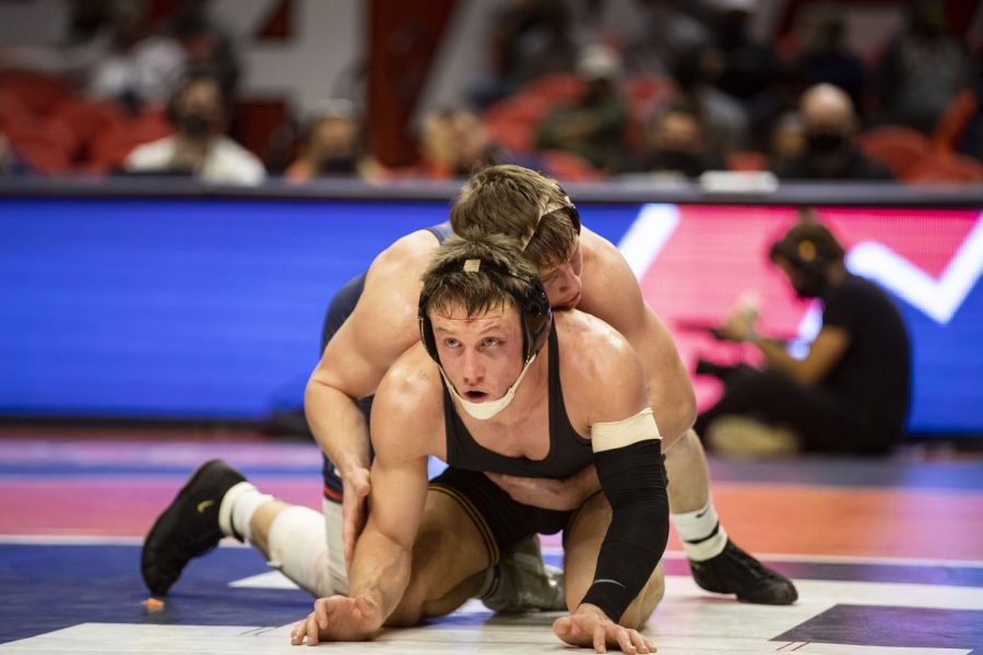 Iowa’s 149-pound No. 12 Max Murin wrestles Illinois’ Christian Kanzier during a wrestling dual between No. 2 Iowa and No. 21 Illinois at State Farm Center in Champaign, IL on Sunday, Jan. 16, 2022. Murin defeated Kanzier, 9-3, by decision. The Hawkeyes defeated the Fighting Illini 36-3. 