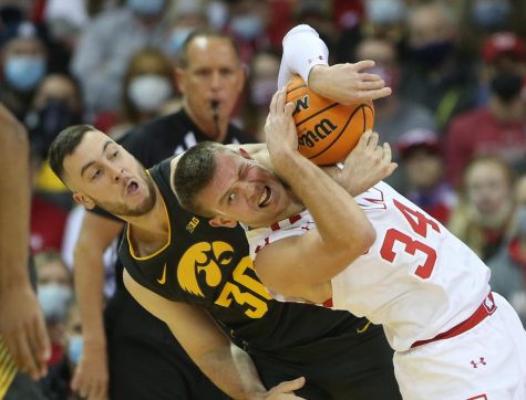 Jan 6, 2022; Madison, Wisconsin, USA; Wisconsin Badgers guard Brad Davison (34) and Iowa Hawkeyes guard Connor McCaffery (30) fight for a rebound during the first half at the Kohl Center. Mandatory Credit: Mary Langenfeld-USA TODAY Sports