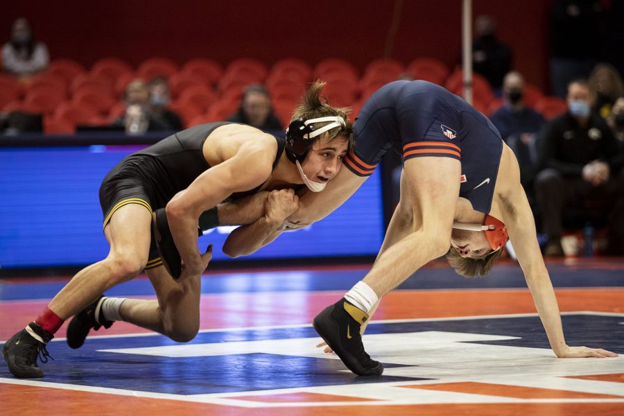 Iowa’s 125-pound No. 12 Drake Ayala wrestles Illinois’ No. 26 Justin Cardani during a wrestling dual between No. 2 Iowa and No. 21 Illinois at State Farm Center in Champaign, IL on Sunday, Jan. 16, 2022. Ayala defeated Cardani, 7-4, by decision. This is Ayala’s sixth win against ranked opponents. The Hawkeyes defeated the Fighting Illini 36-3. 