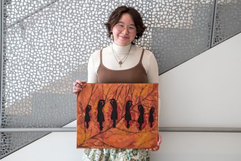 Student Ella Davis poses for a portrait with her art on Saturday, Jan. 22, 2022. This piece was done in collaboration with Trumpet Studio member Sara Lyons.
