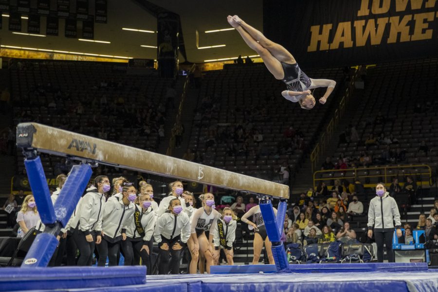 Iowa’s Bridget Killian dismounts the beam during the Women’s Gymnastics Cancer Awareness Meet between Iowa and Penn State at Carver-Hawkeye Arena on Friday, Feb. 4, 2022. Killian earned 9.800 points for the beam. The Hawkeyes defeated the Nittany Lions 196.125 - 195.325.