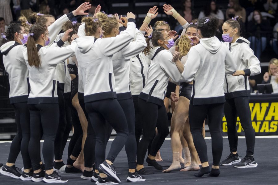 The Iowa gymnastics squad celebrates Alex Greenwald’s floor routine during the Women’s Gymnastics Cancer Awareness Meet between Iowa and Penn State at Carver-Hawkeye Arena on Friday, Feb. 4, 2022. The Hawkeyes defeated the Nittany Lions 196.125 - 195.325.