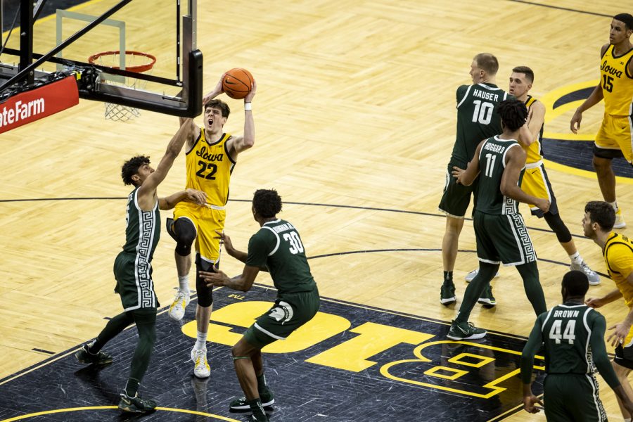 Iowa forward Patrick McCaffery fights his way through defenders for a layup during a men’s basketball game at Carver-Hawkeye Arena between No. 25 Iowa and Michigan State on Tuesday, Feb. 22, 2022. McCaffery scored five points. The Hawkeyes defeated the Spartans, 86-60.
