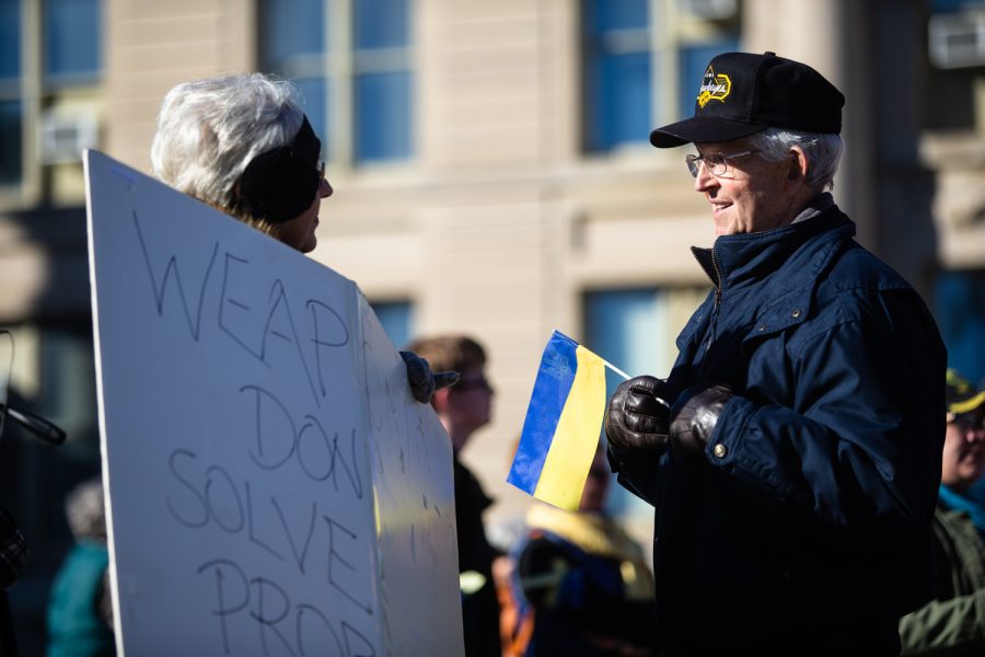 Demonstrators talk to each other during a demonstration for peace in Ukraine on the Pentacrest at the University of Iowa in Iowa City. Around 60 people attended the demonstration. 