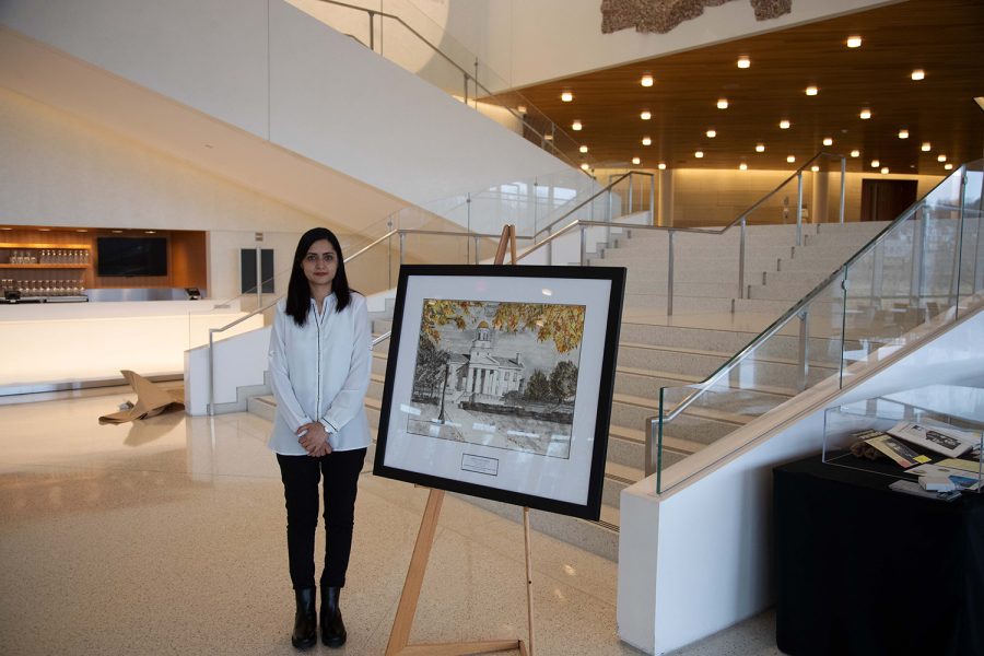 University of Iowa student Gul Rukh Mehboob stands next to her painting for the 175th anniversary of the University of Iowa on Feb. 24, 2022.