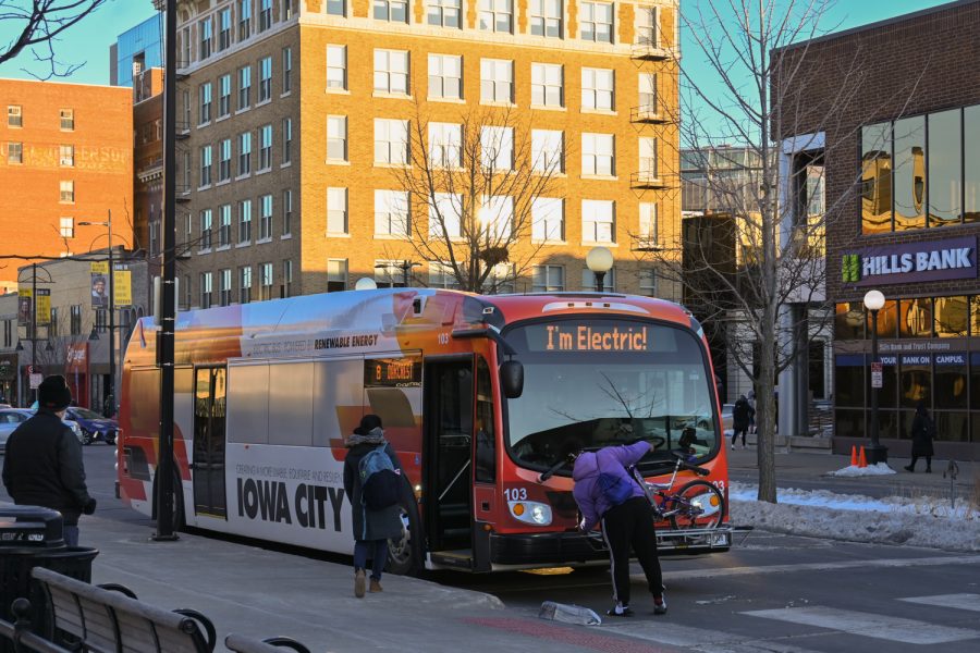An Iowa City community member loads their bike onto the front of a new electric transit bus on February 3, 2022. Iowa City is currently battling a bus driver shortage to start the new year. (Braden Ernst/The Daily Iowan)