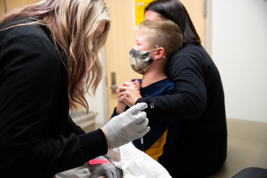 A University of Iowa Hospitals and Clinics staff member prepares to give a COVID-19 vaccine to Keegan Kleppe at the UIHC Riverside Landing Clinic in Coralville, Iowa, on Tuesday, Nov. 3, 2021.