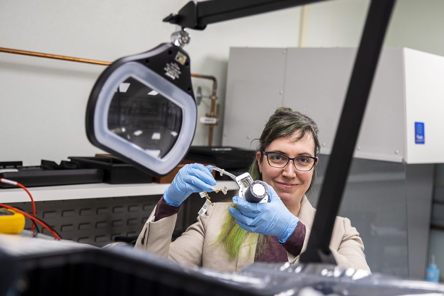 Allison Jaynes, assistant professor of Physics and Astronomy at the University of Iowa, poses for a portrait with a space instrument she designed. Jaynes researches specific mechanisms that run higher energies in Earth’s radiation belts while also building instrumentation for rockets and space craft.