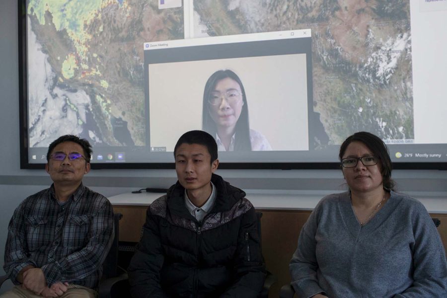 Professor Jun Wang, Lorena Castro García, Xi Chen, and Zhendong Lu pose for a group portrait before their work on the projector. The projector depicts their California wildfire smoke elevations.  