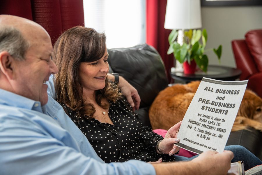 Dale and Juli Wirtjes pose for a portrait with an old advertisement where they first met, at their house in Cedar Rapids on Saturday, Feb. 12, 2022. Juli and Dale have been married for almost 40 years. 