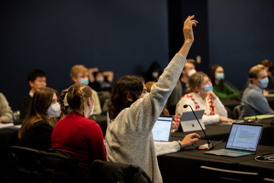 A senator of the University of Iowa’s Undergraduate Student Government raises his hand to ask a question pertaining an amendment during a USG meeting at the Iowa Memorial Union on Feb. 10, 2022. 