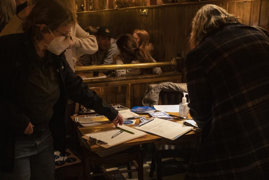 Attendees sign in at the Abby Finkenauer campaign meet and greet at Sanctuary in Iowa City on Thursday, Mar. 3, 2022. 