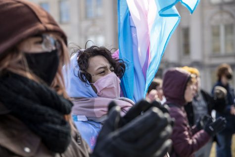 Eleventh-grader Julian Erwin cheers during a transgender rights protest at the Pentacrest on Friday, March 11, 2022. Erwin chose to participate in the walkout because he is a part of the transgender community. “It’s part of my responsibility to support my community.”