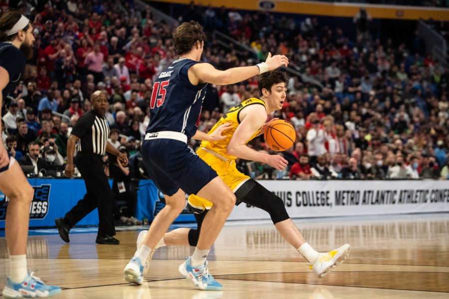Iowa forward Patrick McCaffery attempts to get the ball past Richmond forward Matt Grace during the first round of the NCAA Mens Championship between the Iowa Hawkeyes and the Richmond Spiders at KeyBank Center in Buffalo, N.Y., on Thursday, March 17, 2022. McCaffery earned 18 points. The Spiders beat the Hawkeyes, 67-63.