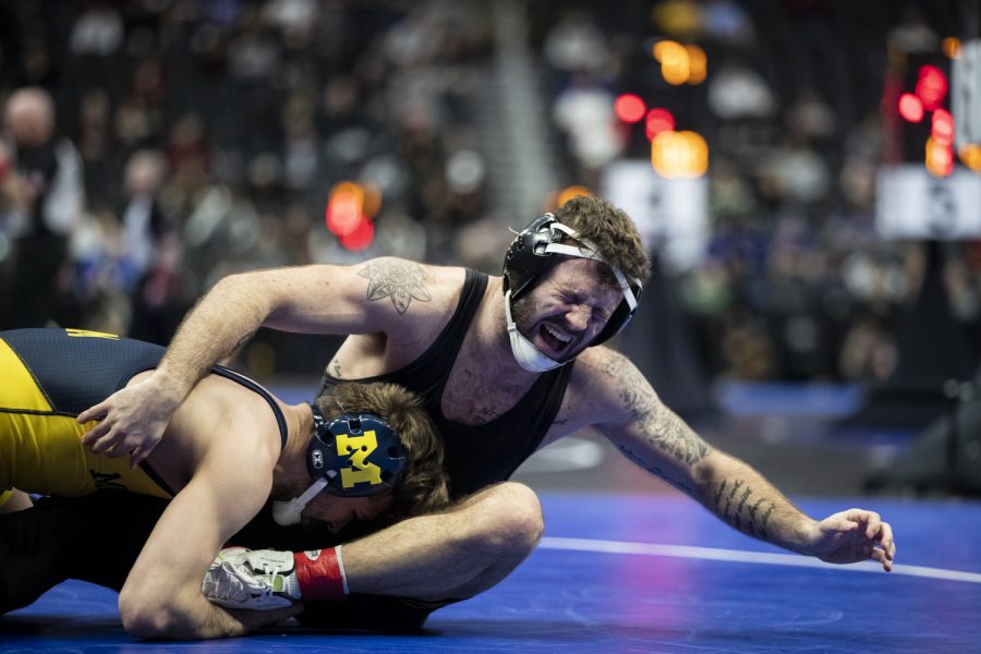 Iowas No. 2 Jaydin Eierman yells in pain after getting taken down by Michigans No. 24 Stevan Micic grapple during session three at the NCAA Wrestling Championships at Little Caesars Arena in Detroit, Mich., on Friday, March 18, 2022. Micic defeated Eierman in a 141-pound match by injury forfeit.