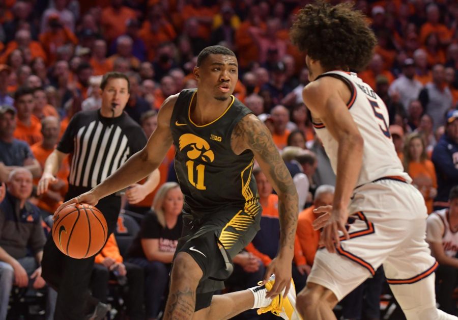 Mar 6, 2022; Champaign, Illinois, USA; Iowa Hawkeyes guard Tony Perkins (11) drives the ball as Illinois Fighting Illini guard Andre Curbelo (5) defends during the second half at State Farm Center. Mandatory Credit: Ron Johnson-USA TODAY Sports