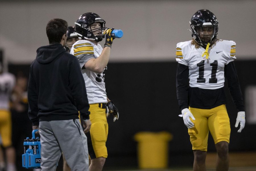 Players take a break during an Iowa football open practice at the Hansen Football Performance Center in Iowa City on Tuesday, March 29, 2022. 