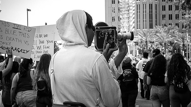 Trevon Coleman uses a Bolex 16mm film camera at March For Our Lives in Orlando, FL. The same camera was used to film portions of the documentary. 