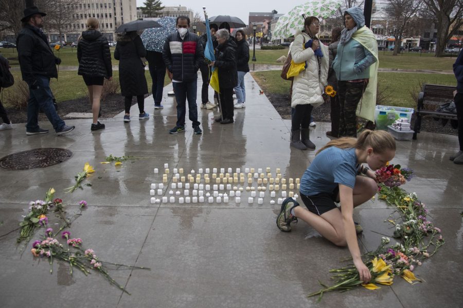 An attendee places a flower at a vigil for Ukraine outside of The Pentacrest in Iowa City on Sunday, April 3, 2022. 