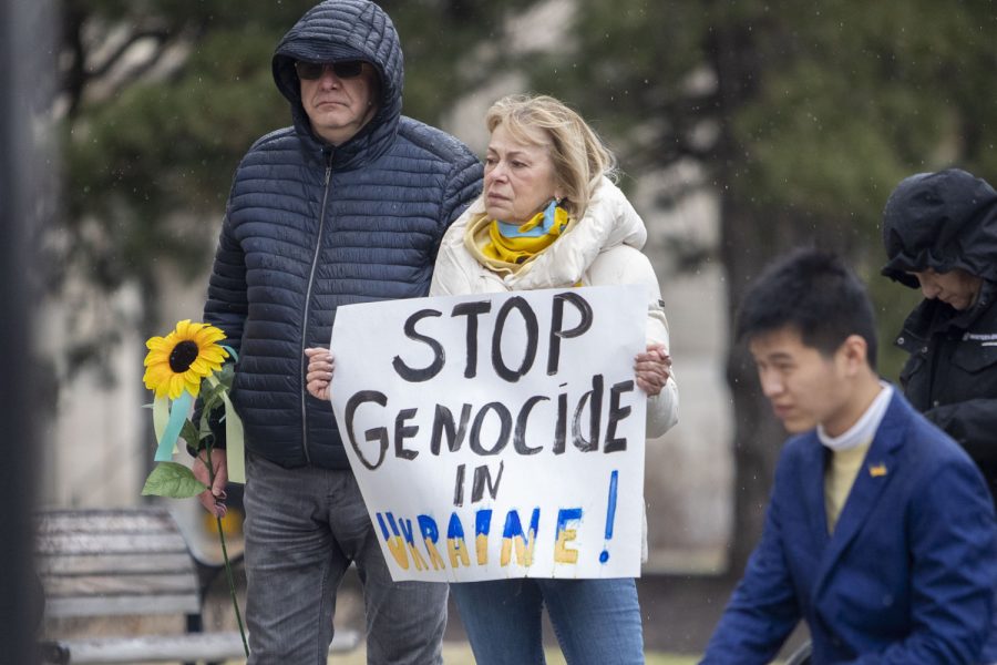 Anatoliy Gordiyenko, a Ukrainian system safety engineer stands with another attendee holding a poster in support of Ukraine at a vigil for Ukraine outside of The Pentacrest in Iowa City on Sunday, April 3, 2022. “This isn’t a fight between Russian and Ukraine,” said Gordiyenko. “It’s a fight between good and evil.” 