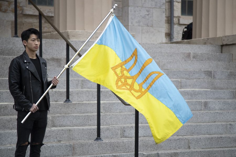 Richard Yu holds a flag at a vigil for Ukraine outside of The Pentacrest in Iowa City on Sunday, April 3, 2022. 