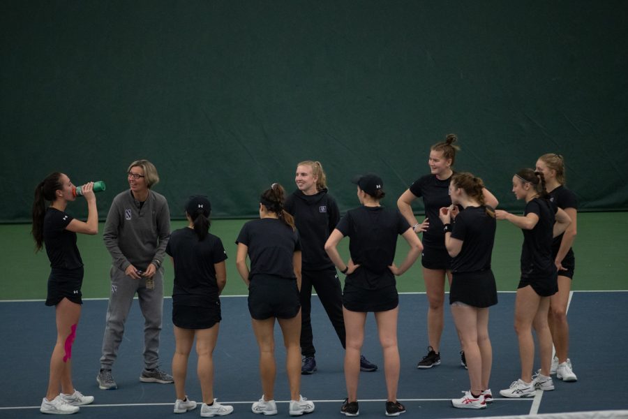 The Northwestern women’s tennis team celebrates during a women’s tennis meet between Iowa and No. 37 Northwestern at the Hawkeye Tennis & Recreation Complex on Sunday, April 3, 2022. The Wildcats defeated the Hawkeyes, 6-1.