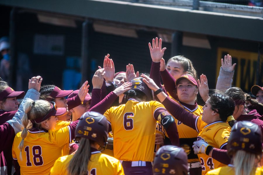 Minnesota congratulates right fielder Chloe Evans after hitting the first home run of the game during a softball game between Iowa and Minnesota at Pearl Field in Iowa City on Sunday, April 10, 2022.  The Golden Gophers defeated the Hawkeyes, 10-2.