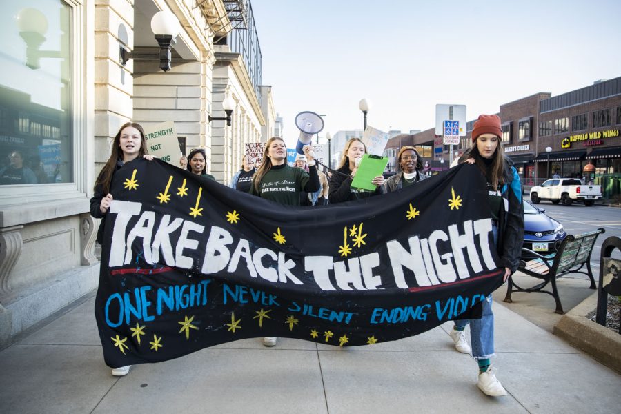 Rally organizers lead the 2022 Take Back the Night march organized by the Women’s Resource and Action Center in Iowa City on Tuesday, April 26, 2022.