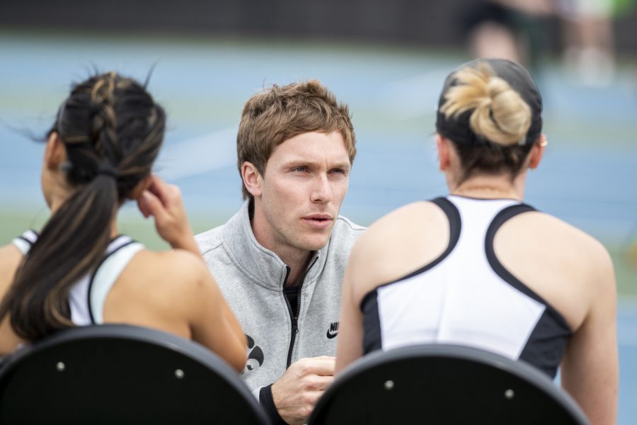 Assistant coach Daniel Leitner consults with players before doubles during a women’s tennis match between Iowa and Michigan State at the Hawkeye Tennis & Recreation Complex on Wednesday, April 27, 2022. The Hawkeyes defeated the Spartans, 4- 3.