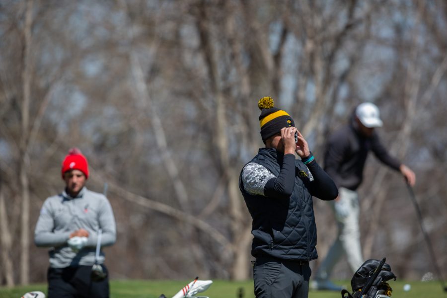Iowa’s Garrett Tighe looks down the field through a range finder during day two of the Hawkeye Invitational at Finkbine Golf Course in Iowa City on April 17, 2022.