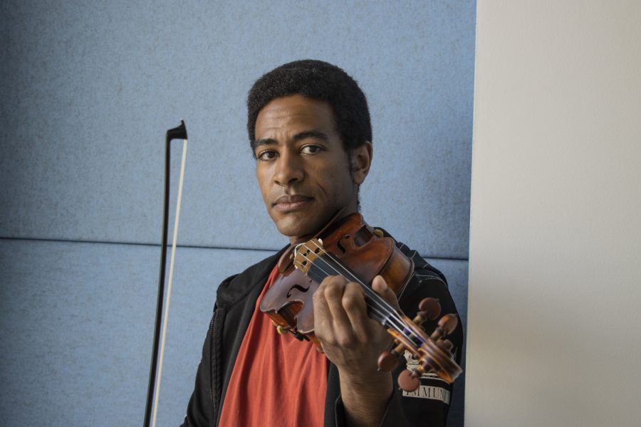 Joshua Henderson, a violinist who is the Grant Wood Artist in Residence at the University of Iowa, poses for a portrait in the Voxman Music Building on Monday, March 28, 2022. 