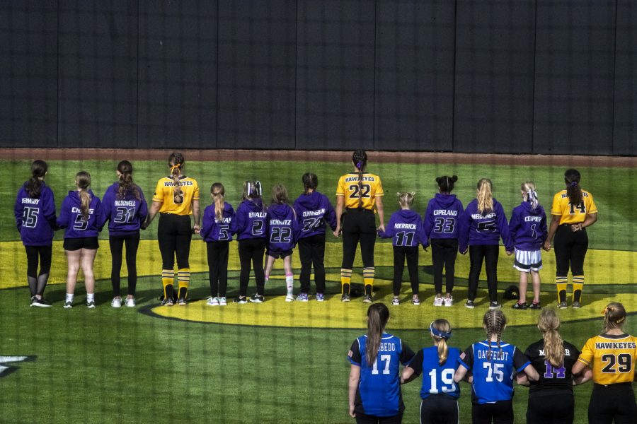 Youth softball teams line up with Iowa for the National Anthem before a softball game between Iowa and Purdue at Pearl Field in Iowa City on Friday, May 6, 2022. The Boilermakers defeated the Hawkeyes, 5-1.