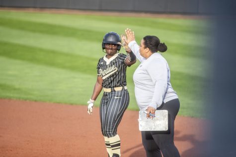 Purdue outfielder Kyndall Bailey high fives associate head coach Dorian Shaw during a softball game between Iowa and Purdue at Pearl Field in Iowa City on Friday, May 6, 2022. Bailey had one RBI. The Boilermakers defeated the Hawkeyes, 5-1.