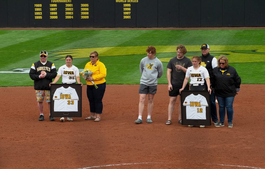 Iowa seniors Riley Sheehy and Kate Claypool stand with their families after a softball game between the Purdue Boilermakers and the Iowa Hawkeyes at Bob Pearl Field in Iowa City on Sunday, May 8, 2022. The Hawkeyes fell to the Boilermakers 4-3.