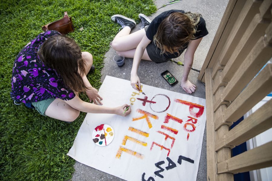 Iowa City City High School students Dakota Thurston and Alex Allton paint on a banner during Banner Art for Abortion Rights at College Green Park in Iowa City on Wednesday, May 11, 2022. Allton spoke about showing up to these events. “This is just part of being a community,” Allton said.