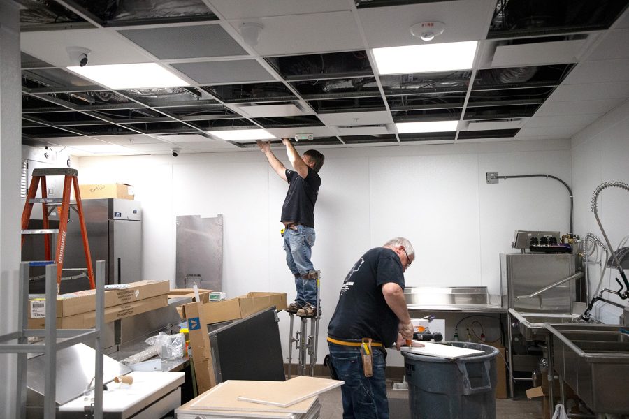 Construction workers work in the kitchen of the Stuffed Olive in Downtown Iowa City on April 29, 2022.