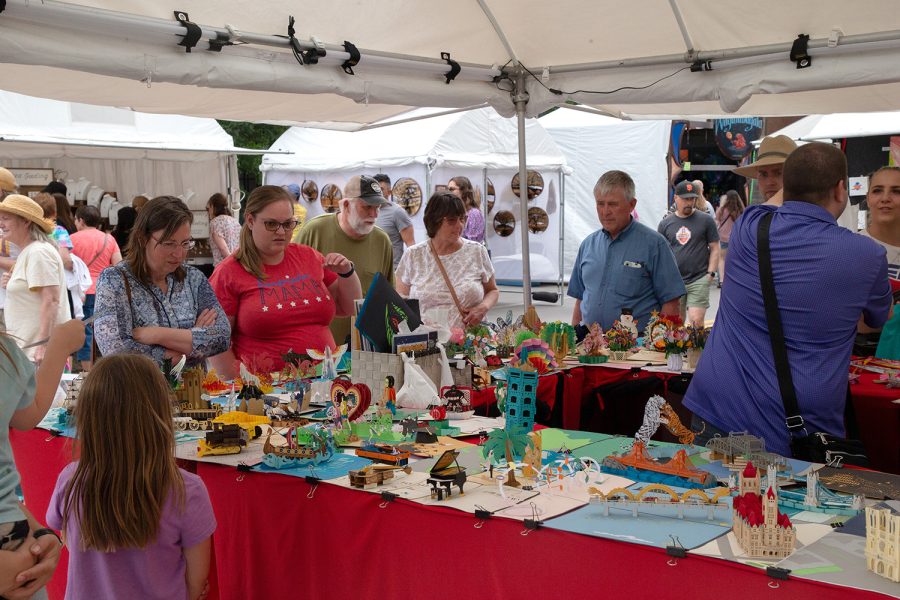 Iowa City residents look at a kirigami display during day two of the 2022 Summer of the Arts Festival in Iowa City on Saturday, June 4, 2022.