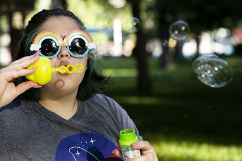 Attendee Rin Bessman, 15, blows bubbles during Pride at the Pool, a pride event hosted by Iowa City Parks and Rec and IC Pride that included a picnic at City Park on Friday, June 17, 2022.